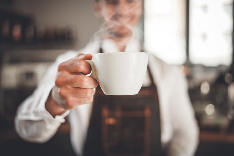 uomo serve tazza di caffè